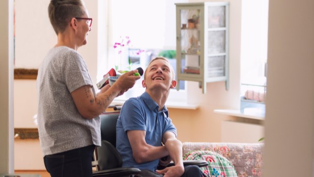 Young disabled man with care assistant